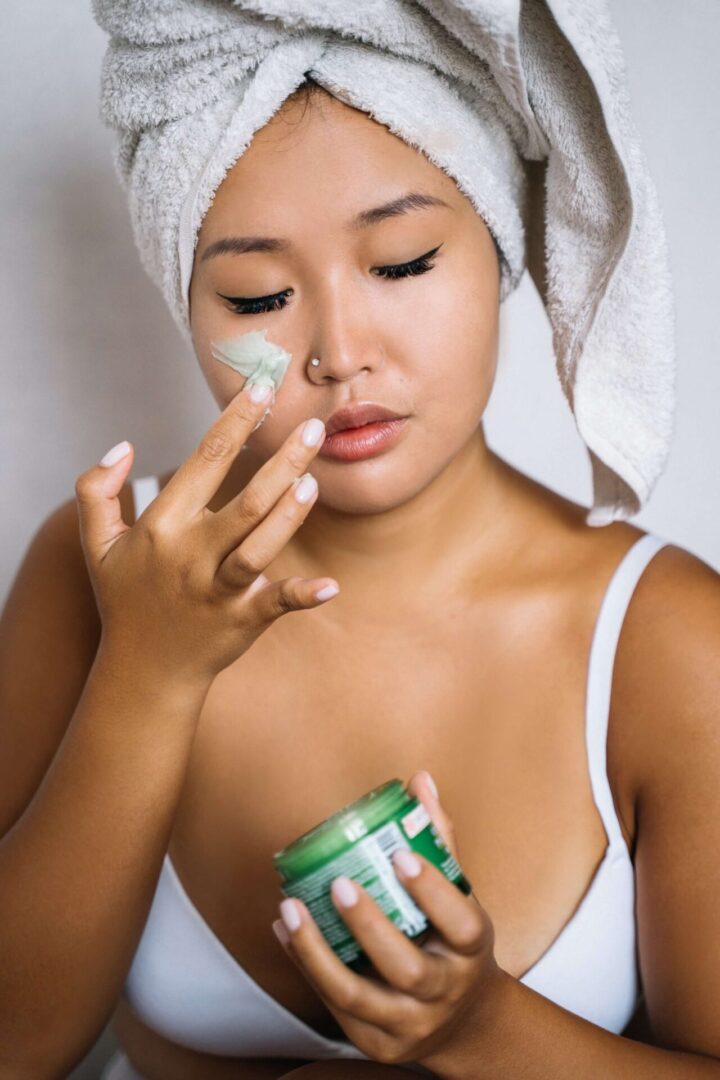 a woman applying cream on her face