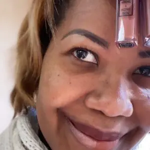 A person holding two liquid makeup containers