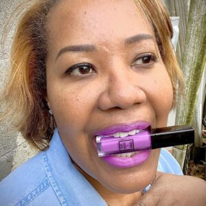 A person wearing a purple liquid lipstick