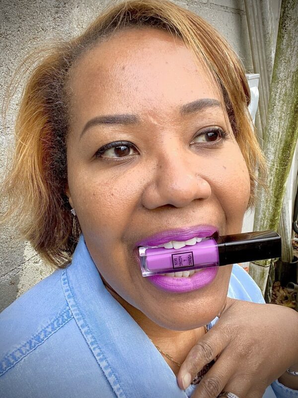 A person wearing a purple liquid lipstick